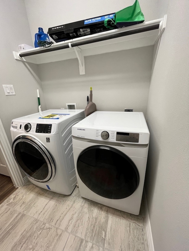 laundry area featuring light wood-type flooring and washing machine and clothes dryer