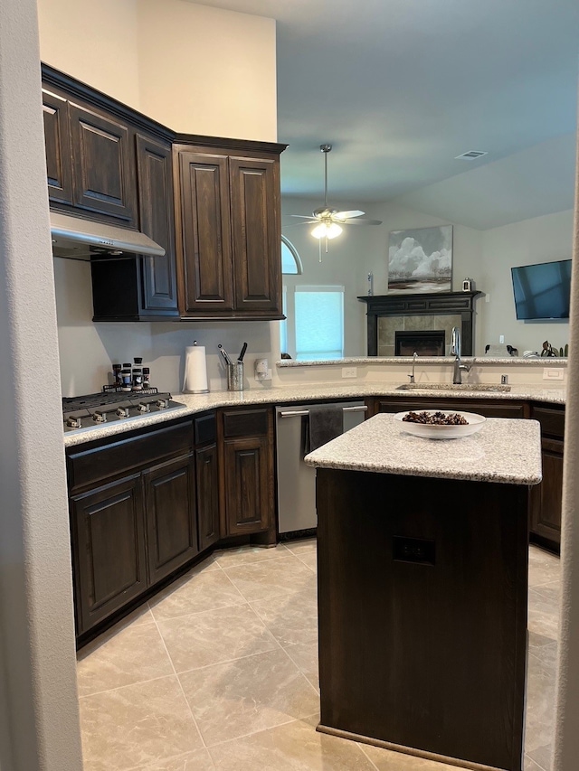 kitchen featuring ceiling fan, a center island, stainless steel appliances, kitchen peninsula, and dark brown cabinets