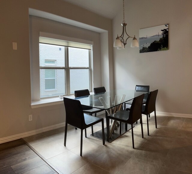 dining area featuring tile patterned flooring and a notable chandelier