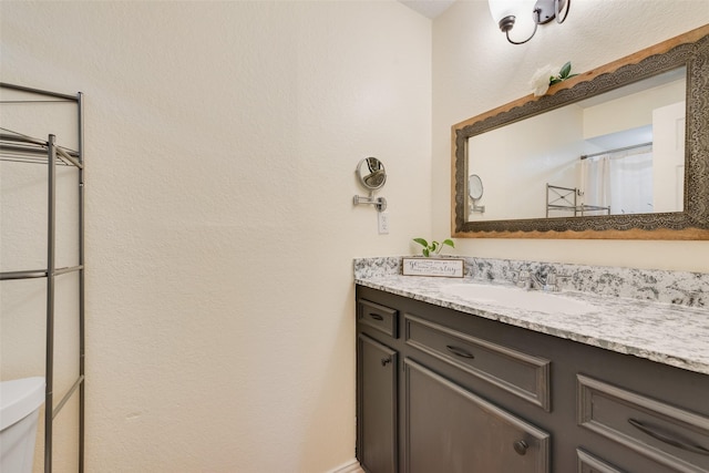 bathroom with a shower with shower curtain, vanity, and toilet