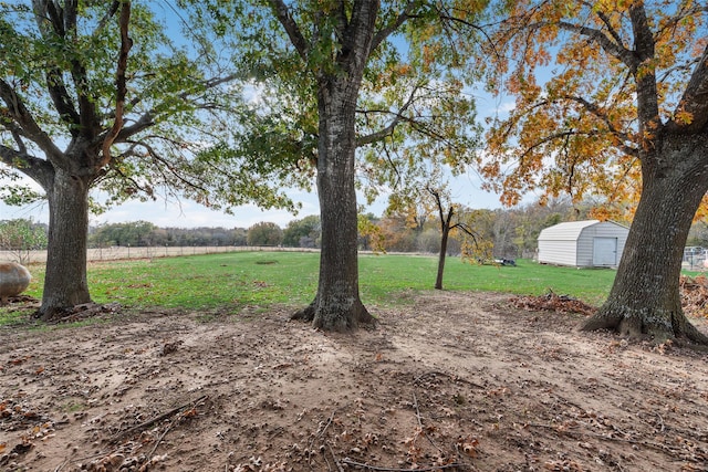 view of yard with a rural view and a storage shed