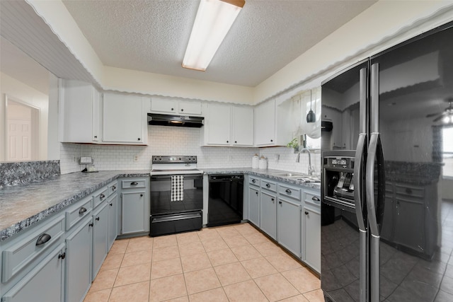 kitchen featuring black appliances, light tile patterned floors, sink, and tasteful backsplash