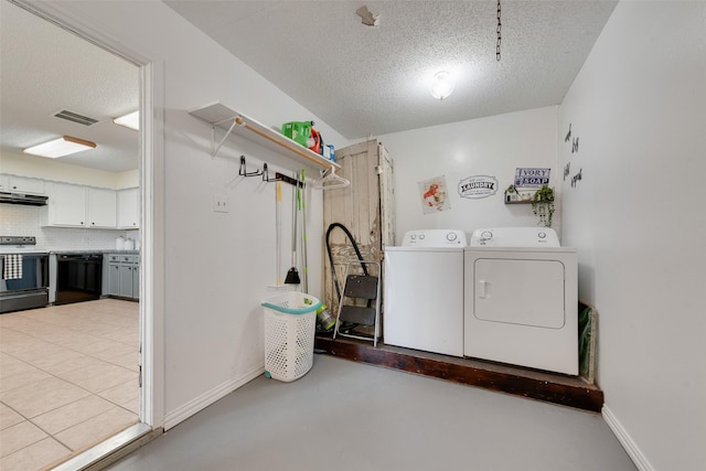 laundry area with washer and clothes dryer and a textured ceiling