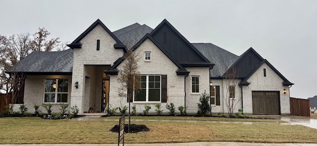 french country inspired facade with a front yard and a garage