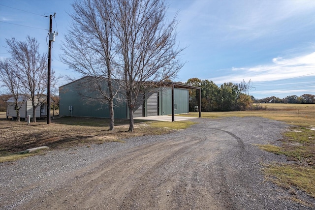 view of front facade with a garage, an outdoor structure, and driveway