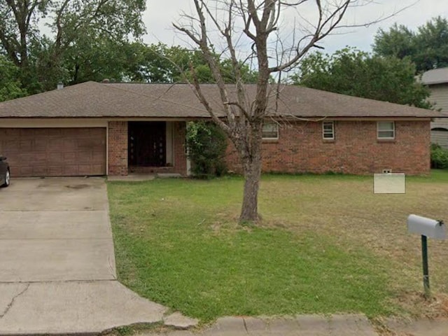 single story home with a front yard and a garage