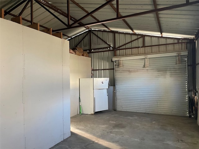 garage featuring freestanding refrigerator and metal wall