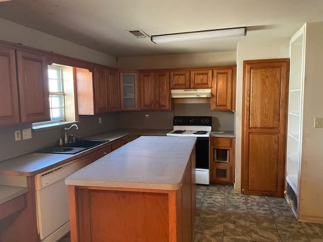 kitchen featuring white appliances, a center island, and sink