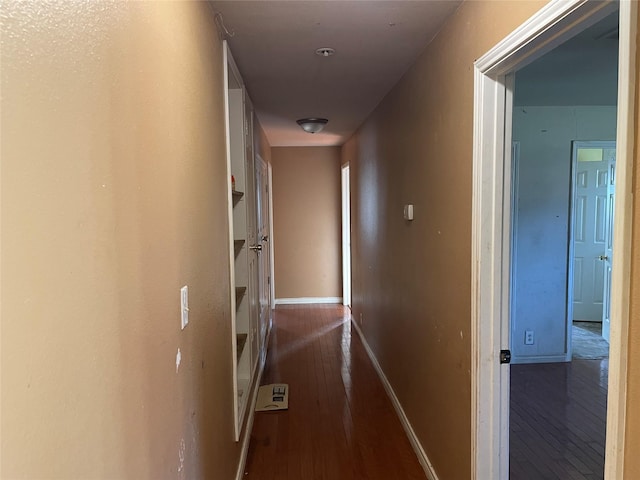 hallway with dark wood finished floors and baseboards