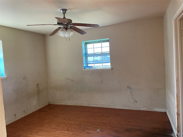 spare room with wood finished floors and a ceiling fan