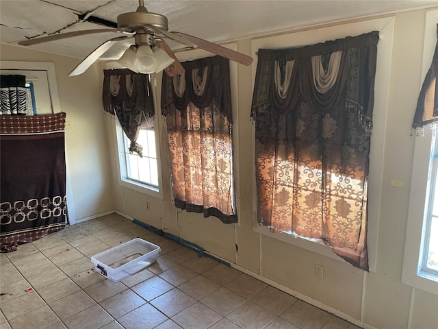 interior space with ceiling fan and light tile patterned flooring