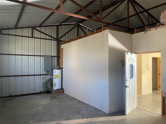 garage featuring electric water heater, metal wall, and electric panel