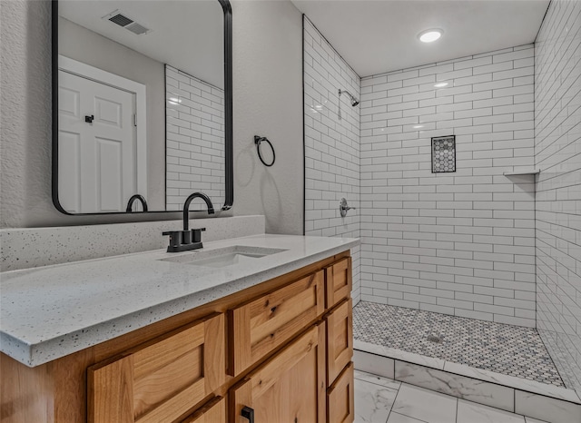 full bath with visible vents, vanity, marble finish floor, recessed lighting, and tiled shower