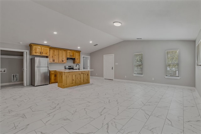 kitchen with a center island with sink, light countertops, baseboards, freestanding refrigerator, and open floor plan