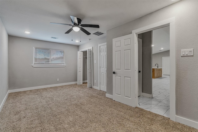 unfurnished bedroom featuring light carpet and ceiling fan