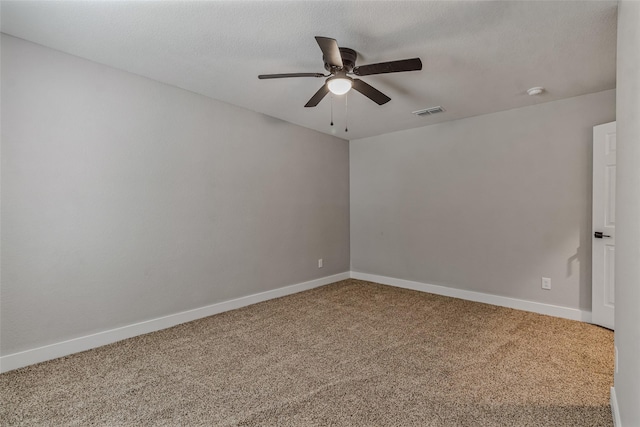 unfurnished room with carpet floors, a ceiling fan, baseboards, and visible vents