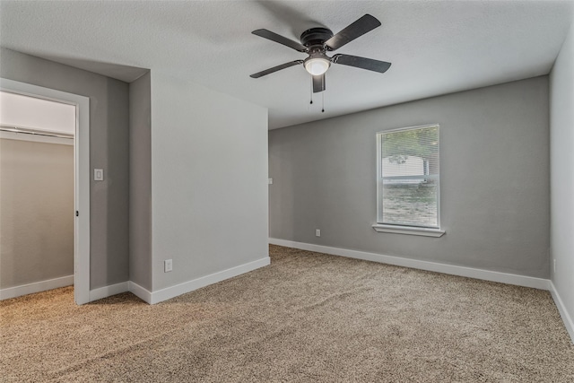 unfurnished room with ceiling fan, carpet, and a textured ceiling