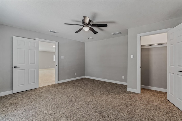 unfurnished bedroom featuring a textured ceiling, a closet, ceiling fan, and carpet flooring