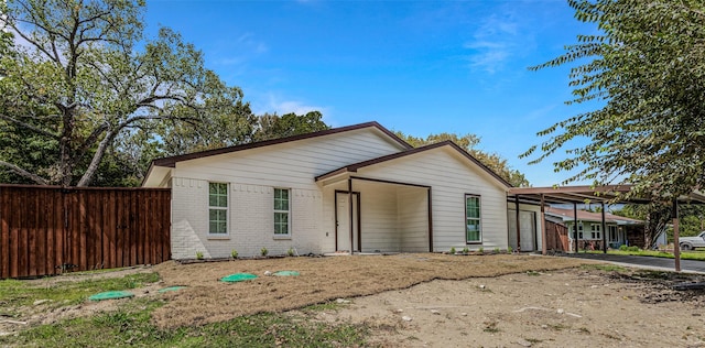 view of front of home featuring brick siding and fence