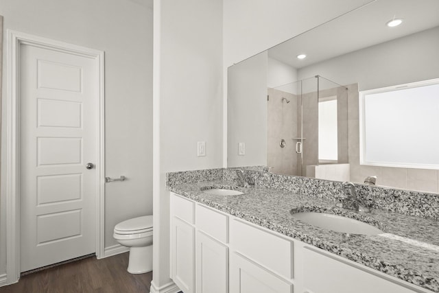 bathroom with vanity, toilet, a shower with door, and hardwood / wood-style floors