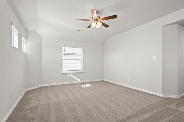 carpeted empty room featuring vaulted ceiling, a wealth of natural light, and ceiling fan