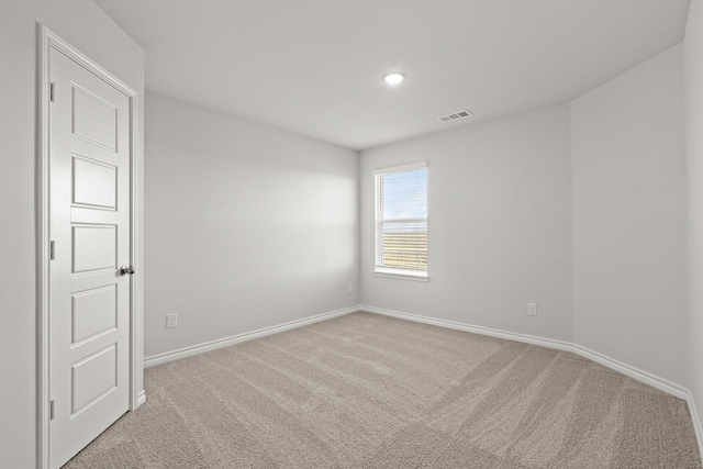 unfurnished room featuring light carpet