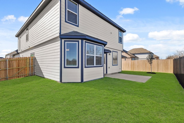 rear view of house featuring a yard and a patio area