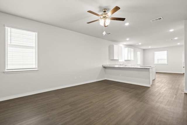 unfurnished living room featuring dark wood-type flooring, ceiling fan, and sink