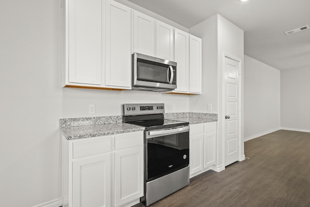 kitchen featuring white cabinetry, light stone counters, dark hardwood / wood-style floors, and appliances with stainless steel finishes