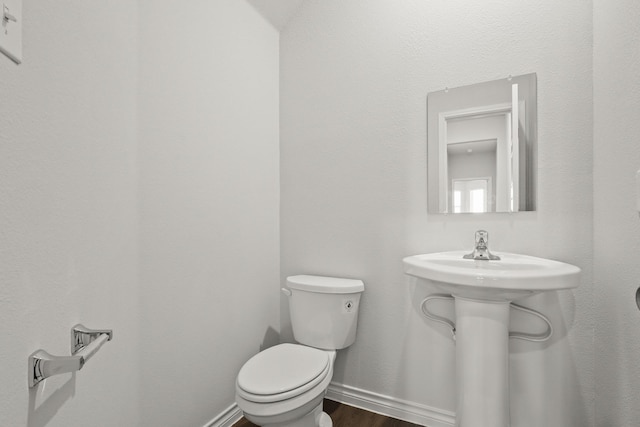 bathroom featuring hardwood / wood-style flooring and toilet