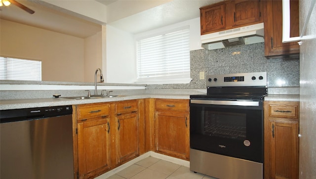 kitchen featuring ceiling fan, sink, stainless steel appliances, backsplash, and light tile patterned floors