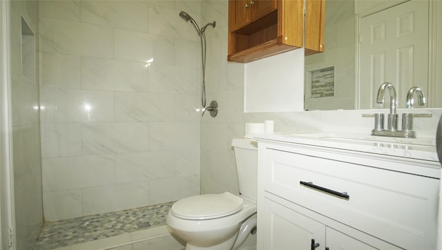 bathroom featuring vanity, tiled shower, and toilet