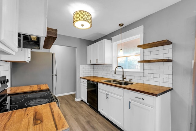 kitchen featuring pendant lighting, wood counters, dishwasher, white cabinets, and stainless steel range