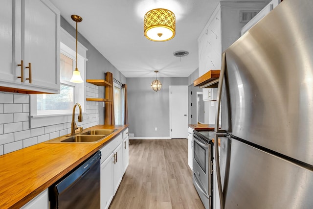 kitchen with pendant lighting, white cabinets, and stainless steel appliances