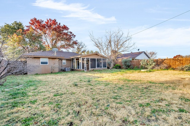 back of house with a lawn, a sunroom, and central AC unit