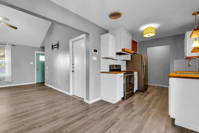 kitchen with white cabinetry, sink, butcher block countertops, decorative backsplash, and appliances with stainless steel finishes