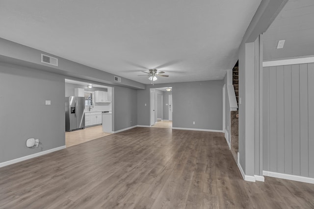 unfurnished living room featuring ceiling fan, light hardwood / wood-style flooring, and sink