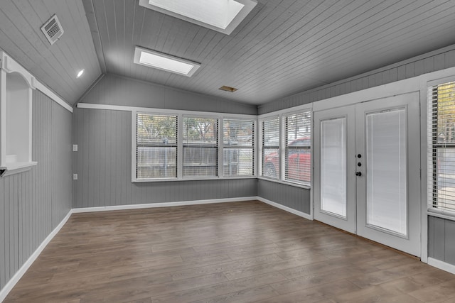 interior space with wood-type flooring, vaulted ceiling with skylight, wooden ceiling, and french doors