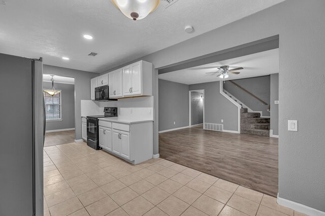 kitchen featuring white cabinetry, ceiling fan, light hardwood / wood-style floors, a textured ceiling, and black appliances