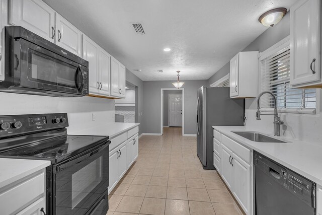 kitchen featuring sink, black appliances, light tile patterned floors, white cabinets, and hanging light fixtures