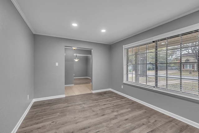 empty room with crown molding and light hardwood / wood-style flooring