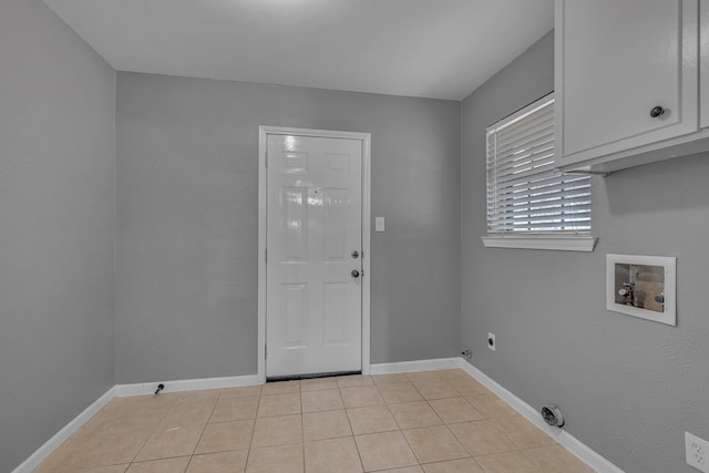 clothes washing area with cabinets, electric dryer hookup, washer hookup, and light tile patterned floors