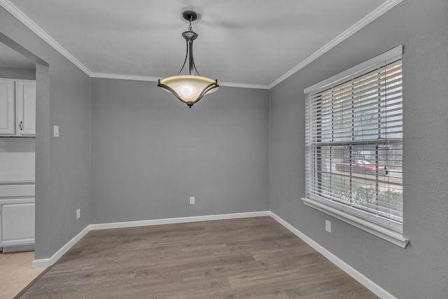 unfurnished dining area featuring light hardwood / wood-style floors and crown molding