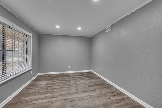 spare room featuring crown molding and hardwood / wood-style flooring