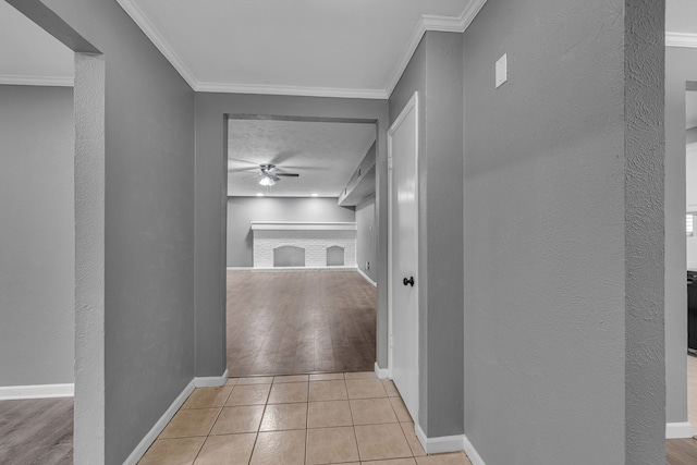 hallway featuring ornamental molding and light tile patterned floors