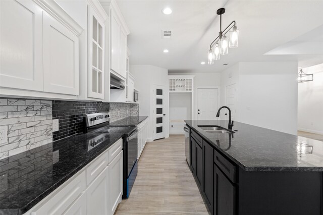 kitchen with appliances with stainless steel finishes, a center island with sink, white cabinetry, and sink