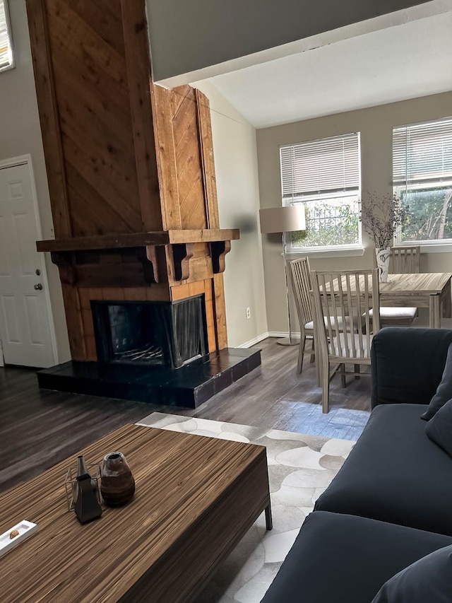 living room featuring hardwood / wood-style flooring, a fireplace, and lofted ceiling