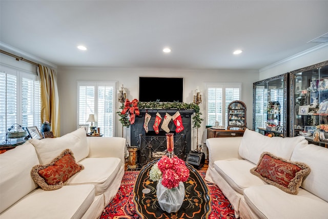 living room featuring a healthy amount of sunlight, crown molding, and a high end fireplace