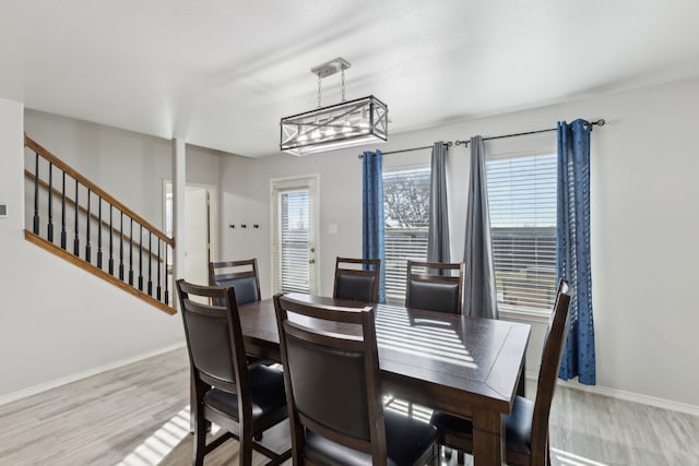 dining space with a notable chandelier and light hardwood / wood-style floors