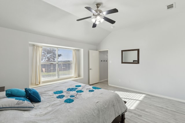 bedroom featuring ceiling fan, light wood-type flooring, and vaulted ceiling